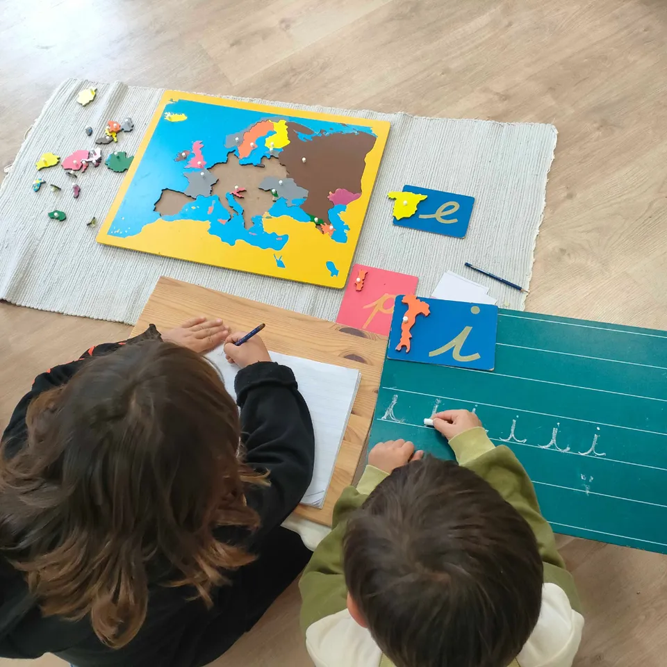 Niños trabajando con mapa Montessori