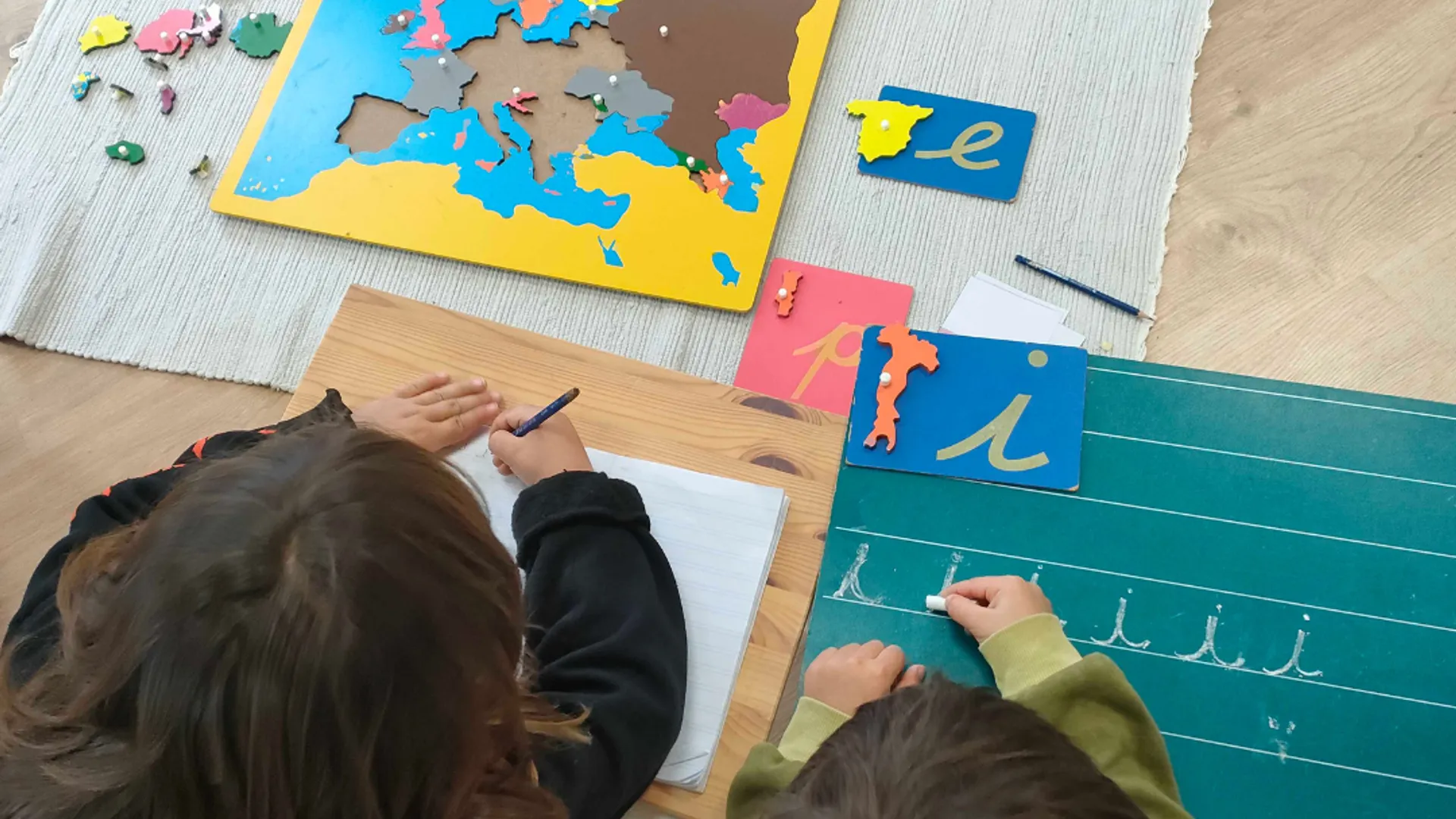 Niños trabajando con mapa Montessori